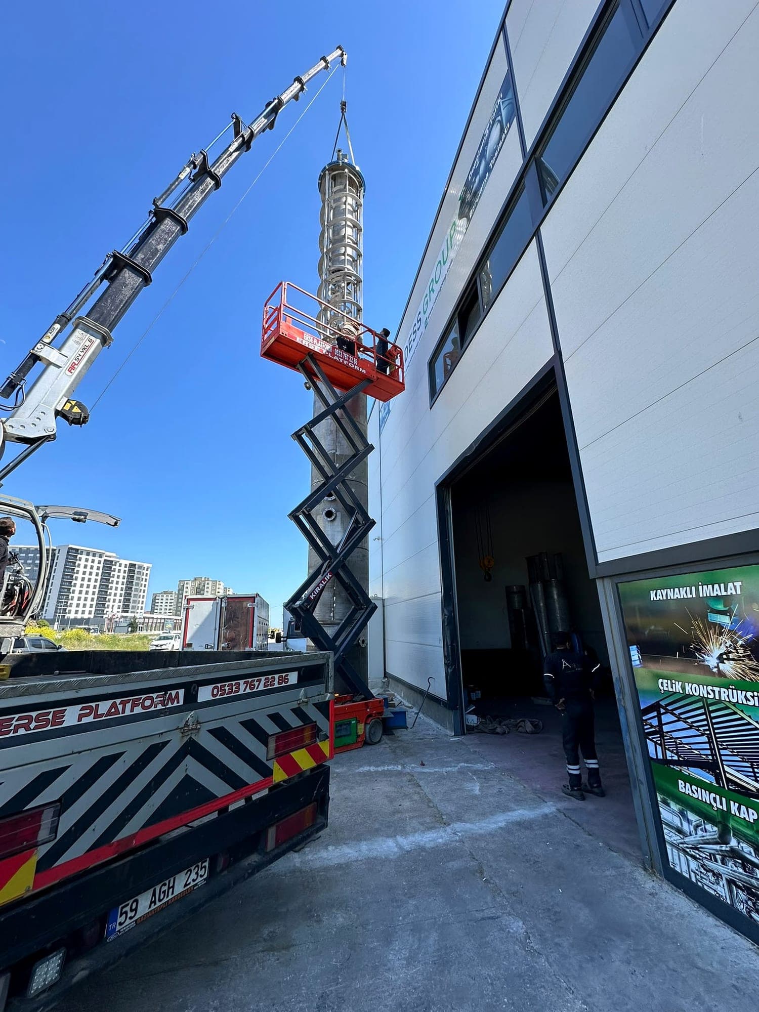 Column internals lifted by crane during on-site assembly from an access platform