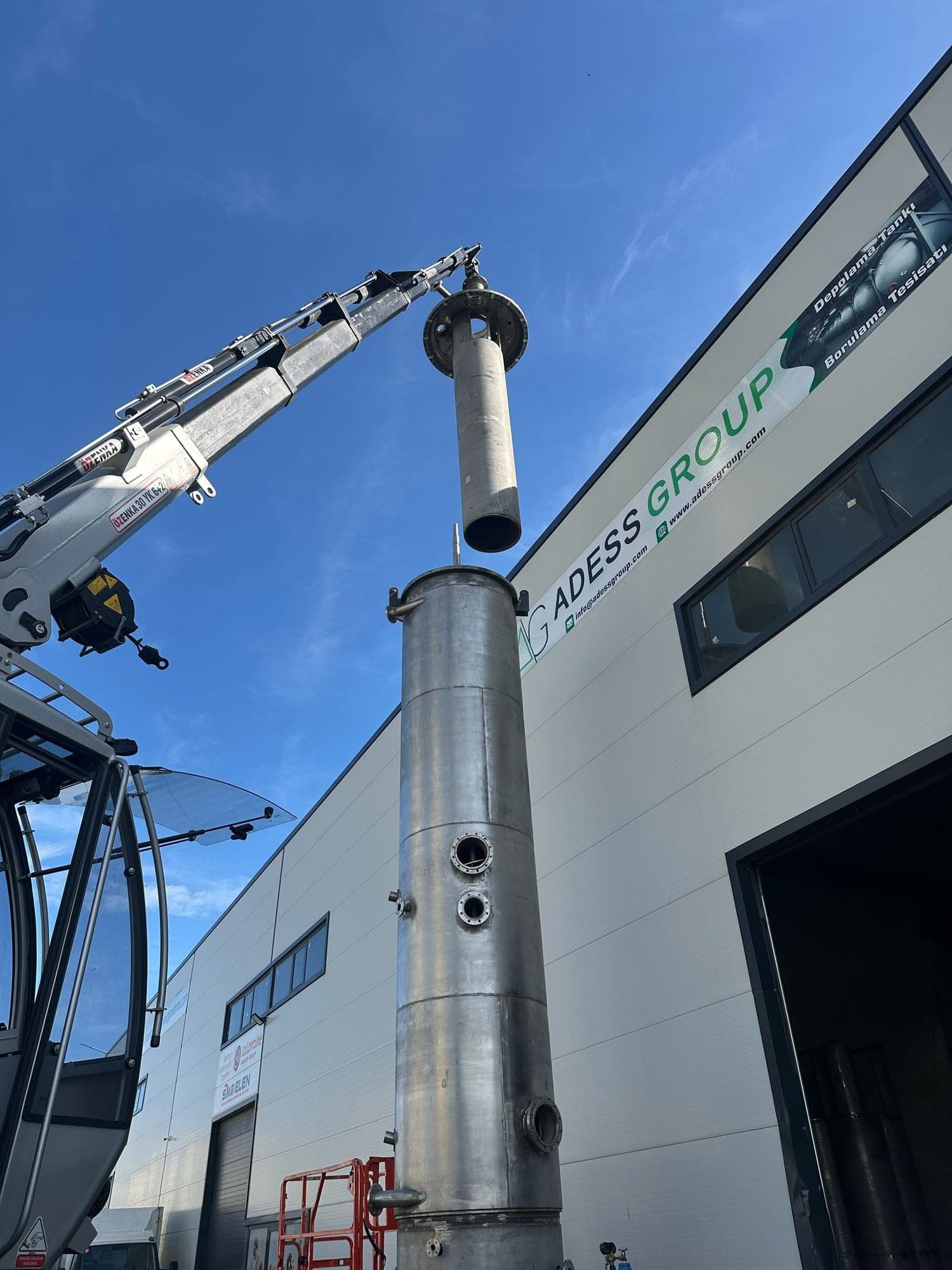 Crane positioning an upper section onto a stainless steel process column