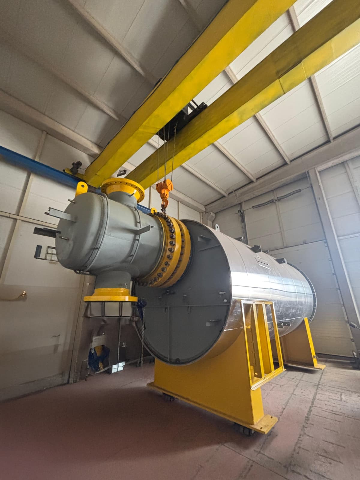 Insulated process vessel with bolted channel head under the overhead crane during assembly